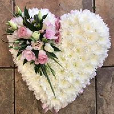 Funeral Based Closed Heart - Based white closed heart tribute, ribbon edging and flower cluster available in any colour of your choice red, orange, yellow, purple, pink etc. At Hearts and Flowers we are delighted to present this product available for flower delivery in Cardiff and surrounding areas